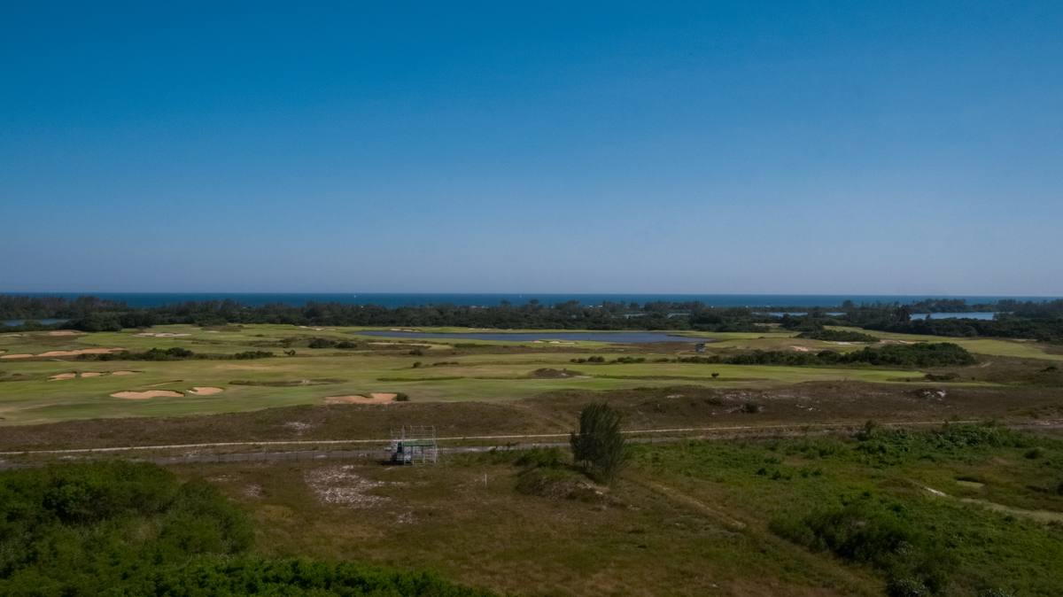 Foto real da região: campo de golfe com a restinga e o mar ao fundo
